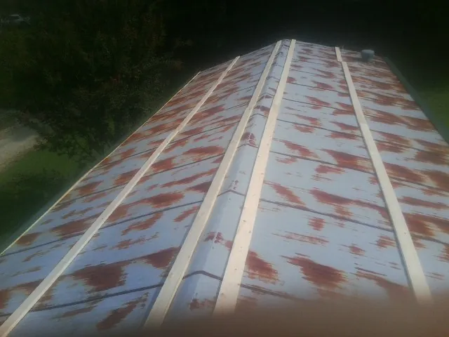 Rusted metal roof panels with new wood purlins before replacement — Storm Damage Roof Repair in Robbins by Roofing Brothers