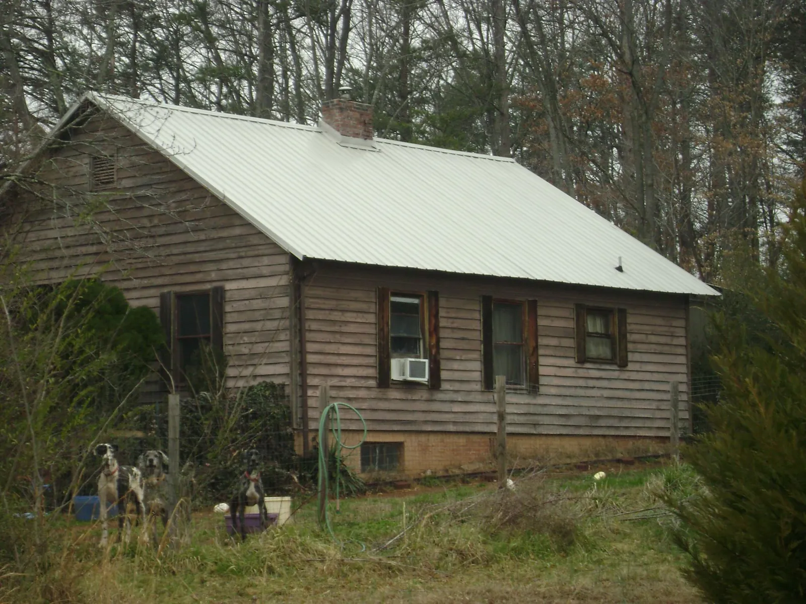 White metal roof on an old wood sided farmhouse, from a Metal Roof Installation job in Robbins